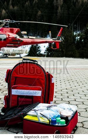 emergency bag and rucksack with medical devices near a rescue helicopter