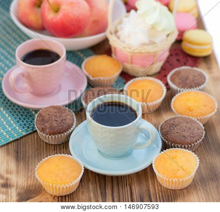 Still life of served coffee cups macaroon cookies marshmallows and apples