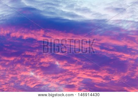 Romantic and dramatic cloud formation on dusk sky. blue and purple cold landscape with sunlight.