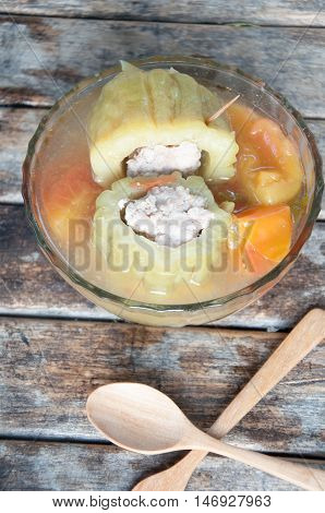 Stuffed bitter gourd with minced pork in clear soup on wood table