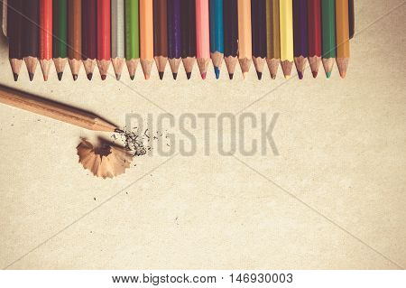 Colored pencils angle / Many different colored pencils on cement background / sharpened pencil with shavings