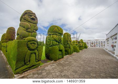 TULCAN, ECUADOR - JULY 3, 2016: human like sculptures on the side of the path on the cemetery.