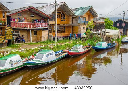 PASTO, COLOMBIA - JULY 3, 2016: some colorfull boats parked on the river next to some shops.