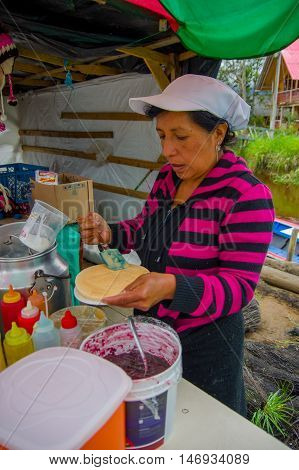 PASTO, COLOMBIA - JULY 3, 2016: unidentified woman preparing a dessert with caramel and a wafer in a location close to la cocha lake.