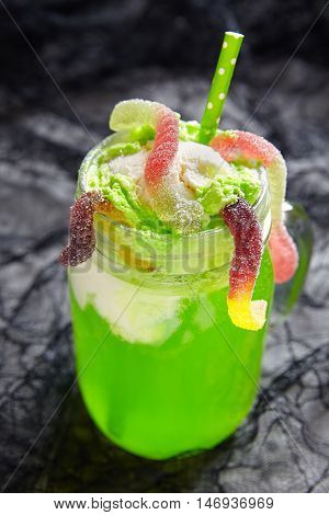 Green drink with ice cream float and gummy worms for Halloween