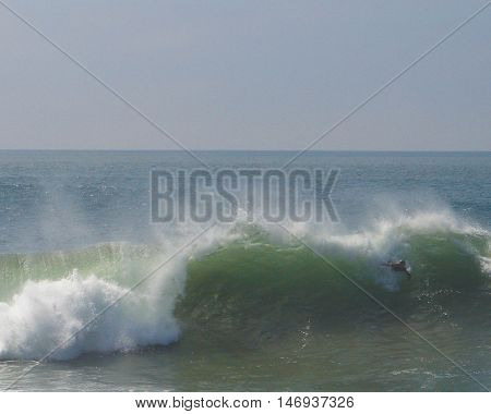 Unidentifiable  body surfer enjoys the big swell at The Wedge in Newport Beach, CA
