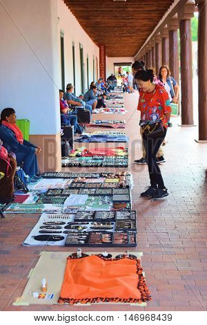 Santa Fe, NM - August 29, 2016:  Native Americans selling their merchandise at the courtyard of the historic adobe style Palace of the Governors Building built in 1610 which has been a government building for centuries taken in Santa Fe, NM.