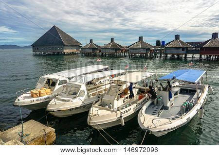 Semporna,Sabah-Sep 10,2016:Speedboats Tour with background of Dragon Inn Floating Resort at Semporna.Its a gateway for diving & snorkeling trips to the islands of Sipadan,Mabul,Mataking,Maiga & others