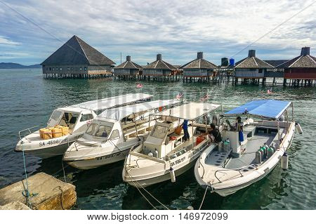 Semporna,Sabah-Sep 10,2016:Speedboats Tour with background of Dragon Inn Floating Resort at Semporna.Its a gateway for diving & snorkeling trips to the islands of Sipadan,Mabul,Mataking,Maiga & others
