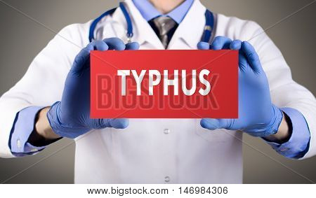 Doctor's hands in blue gloves shows the word typhus. Medical concept.