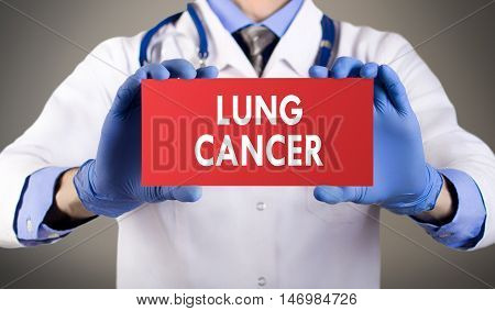 Doctor's hands in blue gloves shows the word lung cancer. Medical concept.