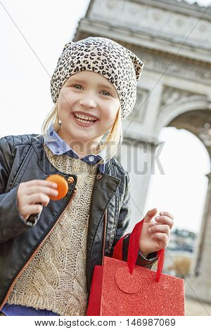 Smiling Child Near Arc De Triomphe Holding French Macaroon