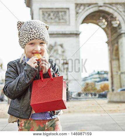 Happy Child Near Arc De Triomphe In Paris Eating French Macaroon