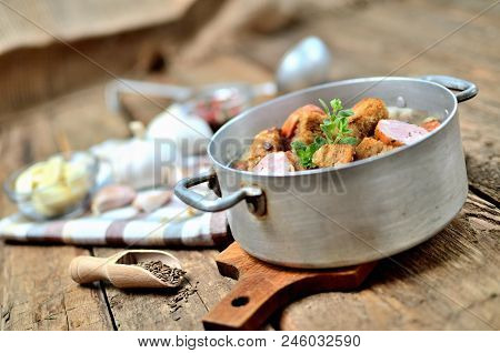 Old Saucepan With Garlic Soup, Fresh Garlic Bulbs, Cloves, Colored Pepper, Wooden Spoon, Croutons, L