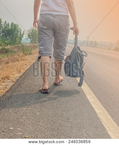 A Young Woman Carrying A Bag Walking On The Streets Alone. Sweltering Sun
