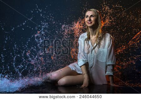 Nice Girl In The White Shirt And Water Drops Behind And Arround Her Illuminated By Light During A Ph
