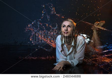Nice Girl In The White Shirt And Water Drops Behind And Arround Her Illuminated By Light During A Ph