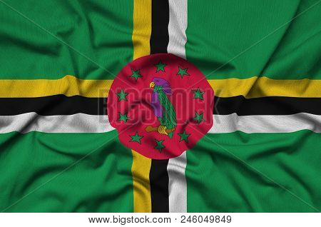 Dominica Flag  Is Depicted On A Sports Cloth Fabric With Many Folds. Sport Team Waving Banner