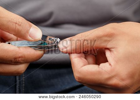 Man Cutting Fingernails With A Nail Clipper