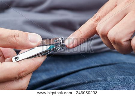 Man Cutting Fingernails With A Nail Clipper