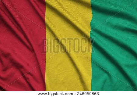 Guinea Flag  Is Depicted On A Sports Cloth Fabric With Many Folds. Sport Team Waving Banner