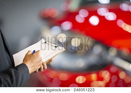 Career Man Saleman Business Inspection Writing On Notepad Or Book, Paper With Car Blurry Background.