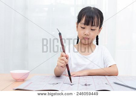 Asian Little Chinese Girl Practice Chinese Calligraphy At Home
