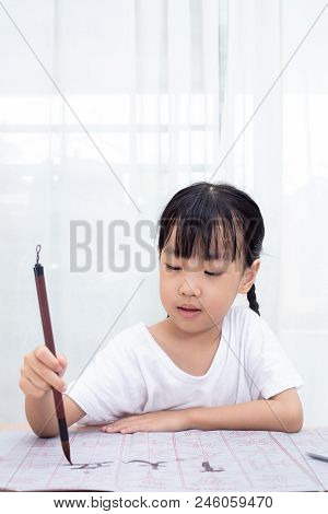Asian Little Chinese Girl Practice Chinese Calligraphy At Home