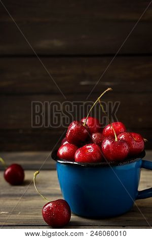 Fresh Cherry With Beautiful Drops In A Blue Enamel Mug