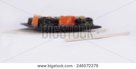 Different Types Of Maki Sushi On A Black Plate.isolated On White Background