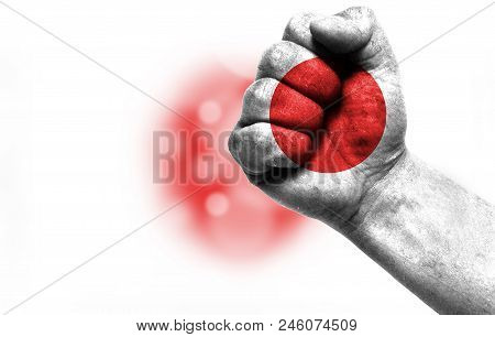 Flag Of Japan Painted On Male Fist, Strength, Power, Concept Of Conflict. On A Blurred Background Wi