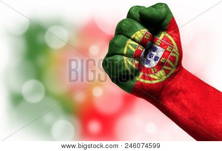 Flag Of Portugal Painted On Male Fist, Strength, Power, Concept Of Conflict. On A Blurred Background