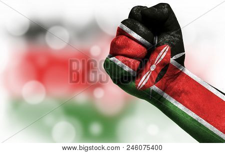 Flag Of Kenya Painted On Male Fist, Strength, Power, Concept Of Conflict. On A Blurred Background Wi