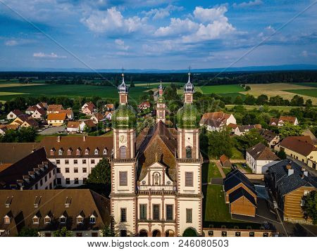 Soaring Majestic Church Saint Maurice In Little French Village Ebersmunster. Aerial Drone View.