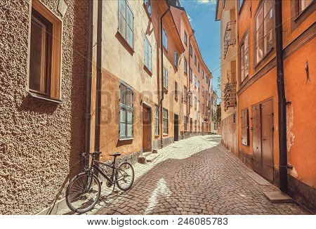 Bicycle Abandoned On Narrow Colorful Street With Old Houses Of Gamla Stan, Old Town In Sockholm, Swe