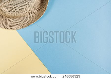 Part Of Straw Hat On Pastel Blue-yellow Background With Copy Space.  Minimalis Vacation Concept.