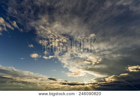 Fantastic Panorama View Of Bright White Gray Dark Wide Puffy Clouds Lit By Sun Spreading Against Dee