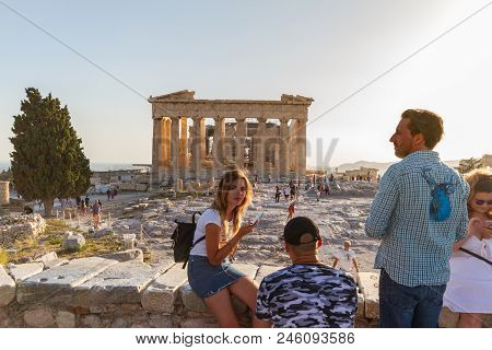 Tourists Posing For Photos On The Acropolis Against The Parthenon On A Summer Afternoon
