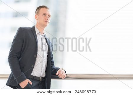 Handsome And Confident Businessman Wear Jecket Suit With Blurred City Center. Successful Young Busin