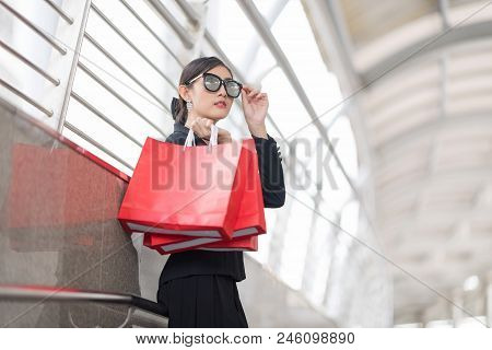 Attractive And Exusive Business Woman Wearing Modern Sunglass With Lot Of Red Shopping Bags. Happy A