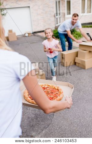 Cropped Image Of Woman Holding Pizza And Daughter With Cup Of Cola Running To Her