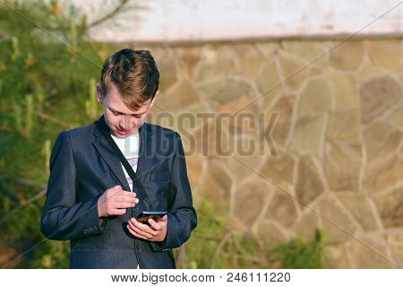A Boy With A Smartphone Reads A Message In A Smartphone