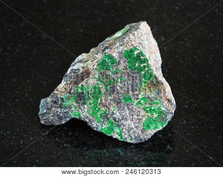 Macro Shooting Of Natural Mineral - Green Uvarovite Crystals On Rough Chromite Stone On Black Granit