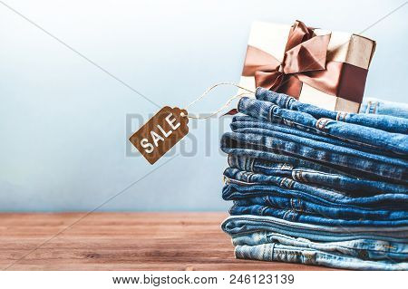 Concept Sales, Black Friday Discounts With Tag, Blue Jeans And Gift On A Light Background Copyspace 