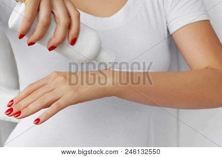 Close Up Of A Girl Hands Holding A Bottle Of Lotion  Hand Cream. Hand Holding Cosmetic Plastic Bottl