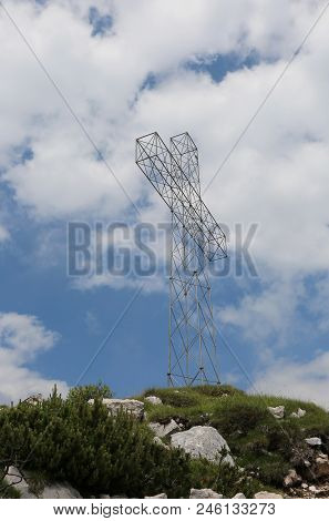 Top Of Moutnain With Big Cross And Sky With White Clouds