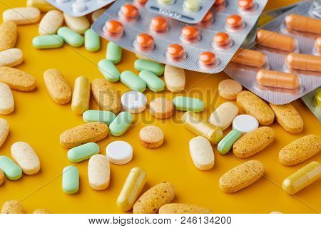 Pills And Capsules. Pile Of White Capsules And Redish Tablets Used As Medication Or Supplements