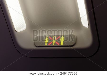 Occupied Lavatory Sign On The Commercial Airlines. Dark Background With Two Bright Lamps.