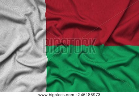 Madagascar Flag  Is Depicted On A Sports Cloth Fabric With Many Folds. Sport Team Waving Banner