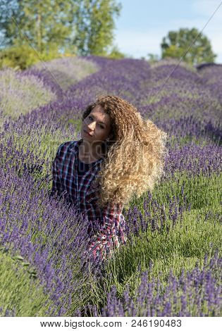 Ostrow, Poland - June 6, 2018: Beautiful  Woman With Long Curly Hair In The Middle Of A Lavender Fie